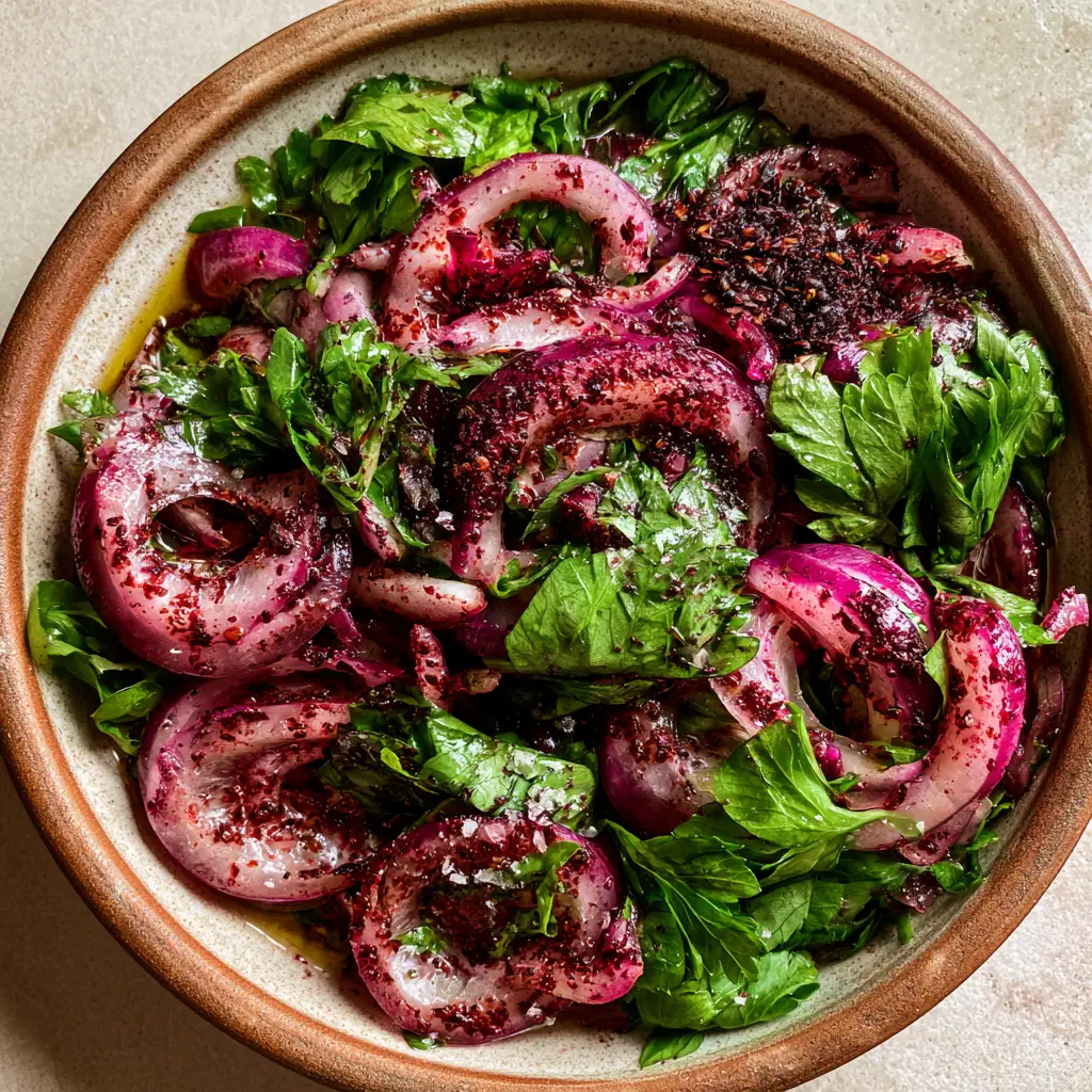 Close up of sumac-stained red onions and fresh emerald parsley in a Turkish salad.