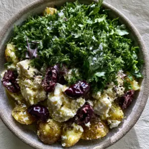 Top-down view of Greek potato salad with fork-tender gold potatoes and glossy lemon vinaigrette.
