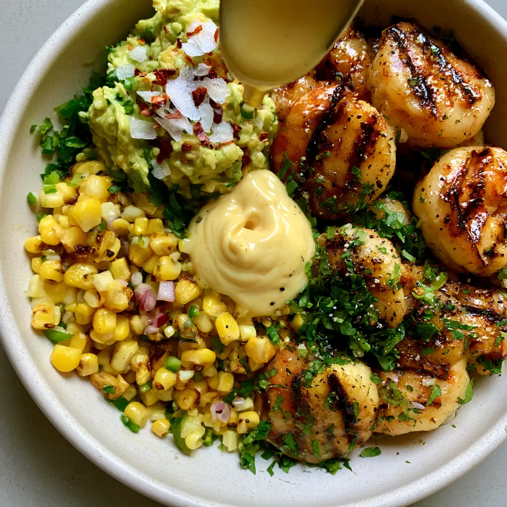 Extreme close-up of grilled shrimp avocado bowls showing dark char marks on shrimp and glistening honey-lime glaze.