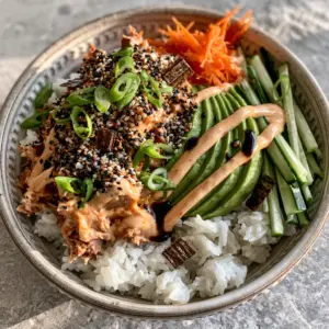 Close up of glossy spicy tuna and matchstick cucumbers in a spicy tuna bowl.