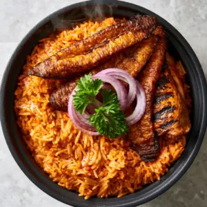 Macro shot of glistening orange-red grains of Riz Jollof Nigérian with steam rising.