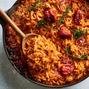 Top-down view of Cameroonian Jollof Rice showing individual long-grain parboiled rice and vibrant sauce.